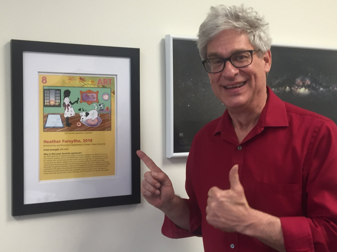 Photo of man pointing at art showing thumbs up sign.